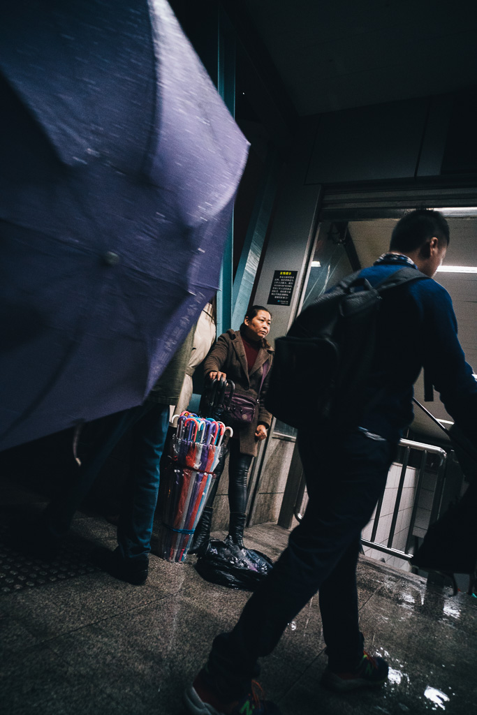 "Selling Umbrellas by Metro Exit when Unexpected Rain Came" by Gino Zhang, on Flickr, on 500px